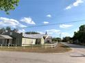Street view of a well-maintained one-story home with a white picket fence at 100 John St, Frostproof, FL 33843