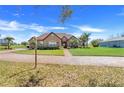 Beautifully landscaped home with a brick driveway and a well-manicured lawn at 10544 Spring Lake Dr, Clermont, FL 34711