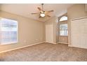 Inviting bedroom with plush carpeting, a ceiling fan, and natural light from the arched window at 107 Broadarrow Pl, Sanford, FL 32773