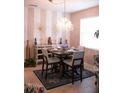 Elegant dining room features a modern chandelier, stylish decor, and comfortable seating for four at 10942 High Bush Ct, Orlando, FL 32825