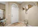 Elegant front foyer featuring a white door, tile flooring, and a decorative wall sculpture at 10942 High Bush Ct, Orlando, FL 32825