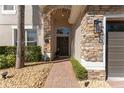 Inviting entryway featuring a stone archway, brick pathway, and lush landscaping, creating a warm welcome at 13643 Budworth Cir, Orlando, FL 32832