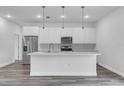 Modern kitchen featuring a large island, stainless steel appliances, and contemporary pendant lighting at 16904 Sw 30Th Avenue Rd, Ocala, FL 34473