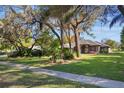 Charming house with mature trees, green lawn, and concrete sidewalk at 17220 Countrybrook Ln, Orlando, FL 32820
