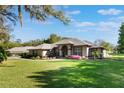 Lovely home with a manicured lawn, mature trees, and colorful flower beds at 17220 Countrybrook Ln, Orlando, FL 32820