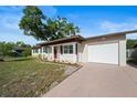 Inviting single story home with a well maintained lawn and attached garage on a sunny day at 2311 Ashland Blvd, Orlando, FL 32808