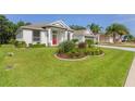 Well-maintained home with lush green lawn and colorful landscaping surrounding the front entrance at 24515 Bocage Way, Leesburg, FL 34748