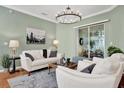 Inviting living room featuring a chandelier, stylish furniture, and sliding glass doors at 24515 Bocage Way, Leesburg, FL 34748