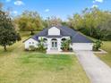 Beautiful home featuring manicured lawn, tropical plants and a lovely entrance at 30912 Fairvista Dr, Tavares, FL 32778