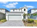 Charming two-story home featuring a two car garage, manicured landscaping, and a gray brick driveway at 3320 Lilac Way, Davenport, FL 33897