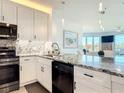 Stylish kitchen featuring modern appliances, granite counters, and white cabinetry at 434 Bouchelle Dr # 202, New Smyrna Beach, FL 32169