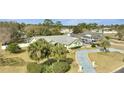 Landscaped yard with palm trees and a long driveway lead to this charming home with a three car garage at 5170 Ne 64Th Ave, Silver Springs, FL 34488