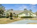 Charming single-story home with lush landscaping, well-manicured lawn, and large arched window at 5170 Ne 64Th Ave, Silver Springs, FL 34488