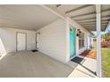 Welcoming home entrance featuring a covered porch with a bright turquoise front door and white exterior at 544 Eartha Ln, Orlando, FL 32805