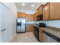 Efficient kitchen design with stainless steel refrigerator, black appliances, and tile flooring at 6612 S Goldenrod Rd # 104A, Orlando, FL 32822