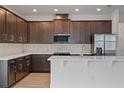 Modern kitchen with dark cabinets, white quartz countertops, and stainless steel appliances at 8013 Colby Cir, Orlando, FL 32817