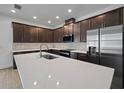 Modern kitchen features a large island, dark cabinets, and stainless steel appliances at 8013 Colby Cir, Orlando, FL 32817