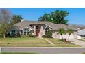 Charming one-story home with a brick and siding exterior, mature trees, and a manicured lawn at 907 Almond Tree Cir, Orlando, FL 32835