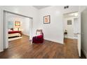 Hallway featuring dark wood floors, with a view into the cozy bedroom with white walls at 908 Cannes Pl, Orlando, FL 32808