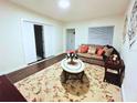 Cozy living room with hardwood floors, neutral paint, and stylish decor, including a beige couch and floral rug at 908 Cannes Pl, Orlando, FL 32808