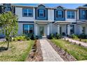 Charming townhome showcases a manicured lawn and welcoming walkway to the front entrance at 9314 Bolshoi Aly, Winter Garden, FL 34787