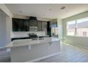 Modern kitchen with stainless steel appliances, spacious island, and dark cabinetry at 9314 Bolshoi Aly, Winter Garden, FL 34787