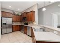 Traditional kitchen features stainless steel appliances, wood cabinetry, and tile backsplash at 10876 Eclipse Lily Way # 60, Orlando, FL 32832