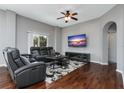 The cozy living room features hardwood floors, a ceiling fan, and a large window for natural light at 10876 Eclipse Lily Way # 60, Orlando, FL 32832