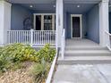 Inviting front porch with white railing and seating area with views of nice landscaping at 1284 Spotted Sandpiper Loop, Winter Springs, FL 32708