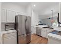 Modern kitchen featuring stainless steel appliances, white cabinets, and wood flooring at 13212 Briar Forest Ct, Orlando, FL 32828