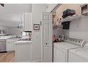 Convenient laundry area with washer, dryer, storage shelves, and organized space, adjacent to the kitchen at 13212 Briar Forest Ct, Orlando, FL 32828