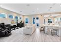 Open-concept living area with white sofa, sleek entertainment center, and lots of windows at 13800 Chauvin Ave, Orlando, FL 32827