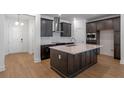 Modern kitchen featuring dark cabinetry, a large island with quartz countertops, and stainless steel appliances at 13809 Luna Harvest Ave, Winter Garden, FL 34787