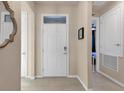 Bright entryway featuring a white door with transom window, beige walls, and tile flooring at 1452 Hopedale Pl, Sanford, FL 32771