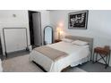 A view of the bedroom offering a bed with neutral bedding, art, and a mirror at 150 E Robinson St # 12A-15 / 1216, Orlando, FL 32801