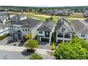 Aerial view of a modern home in a golf course community, featuring dark roof and well-kept landscaping at 1543 Corolla Ct, Reunion, FL 34747