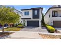 Modern two-story home showcasing a dark garage door, white and dark grey exterior, and manicured landscaping at 1543 Corolla Ct, Reunion, FL 34747