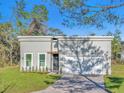 New construction home with a light gray exterior, black trim, and a brick paver driveway at 17135 Sw 41 Ct, Ocala, FL 34473