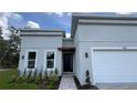 Modern home featuring a two car garage, manicured landscaping, and neutral exterior at 17135 Sw 41 Ct, Ocala, FL 34473