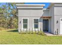 Landscaped front of house with modern gray stucco, black door and brick paver walkway at 17135 Sw 41 Ct, Ocala, FL 34473
