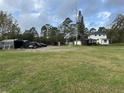Large backyard with multiple storage sheds, parking area, and ample green space at 1955 Mustang Ct, St Cloud, FL 34771