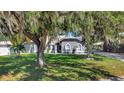 Charming one-story home featuring mature landscaping, arched windows, and a welcoming front entrance at 24 Cypress Ave, St Cloud, FL 34769