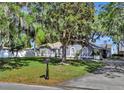 Beautifully landscaped front yard, mailbox, driveway and classic one-story home with charming architectural details at 24 Cypress Ave, St Cloud, FL 34769