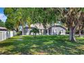 Well-maintained gray one-story home with lush lawn and mature trees in a desirable neighborhood at 24 Cypress Ave, St Cloud, FL 34769