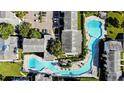 Aerial view of a condo community featuring a winding pool, lush landscaping, and ample parking at 4215 S Semoran Blvd # 2, Orlando, FL 32822