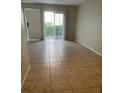 Living room featuring tile floors and a sliding glass door leading to the outside at 4215 S Semoran Blvd # 2, Orlando, FL 32822