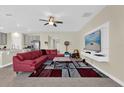 Spacious living room featuring a modern entertainment center and a comfortable red sectional couch at 429 N Andrea Cir, Haines City, FL 33844