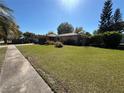 Charming single-story home with a well-manicured lawn and lush landscaping, showcasing curb appeal at 5132 Goldenrod Place Rd, Winter Park, FL 32792
