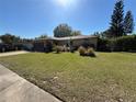 Charming single-story home with a well-manicured lawn and lush landscaping, showcasing curb appeal at 5132 Goldenrod Place Rd, Winter Park, FL 32792