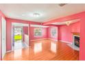 Bright living room features wood flooring, a decorative fireplace, and large windows, offering a cozy ambiance at 5424 Blue Grass St, Orlando, FL 32810